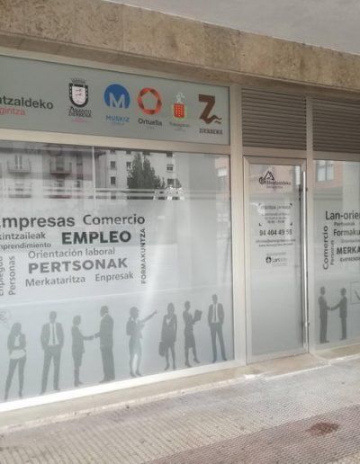 Vinilo decorativo en cristaleras de oficina con diseño institucional y palabras clave en euskera y castellano