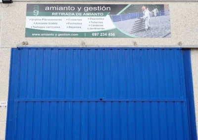Rótulo de nave de Amianto y Gestión terminado en una nave o fachada industrial.