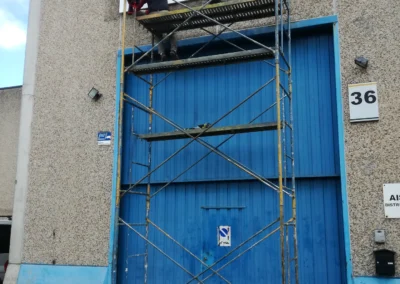 Instalación de rótulo de nave de Camarsa en una nave o fachada industrial con andamio.