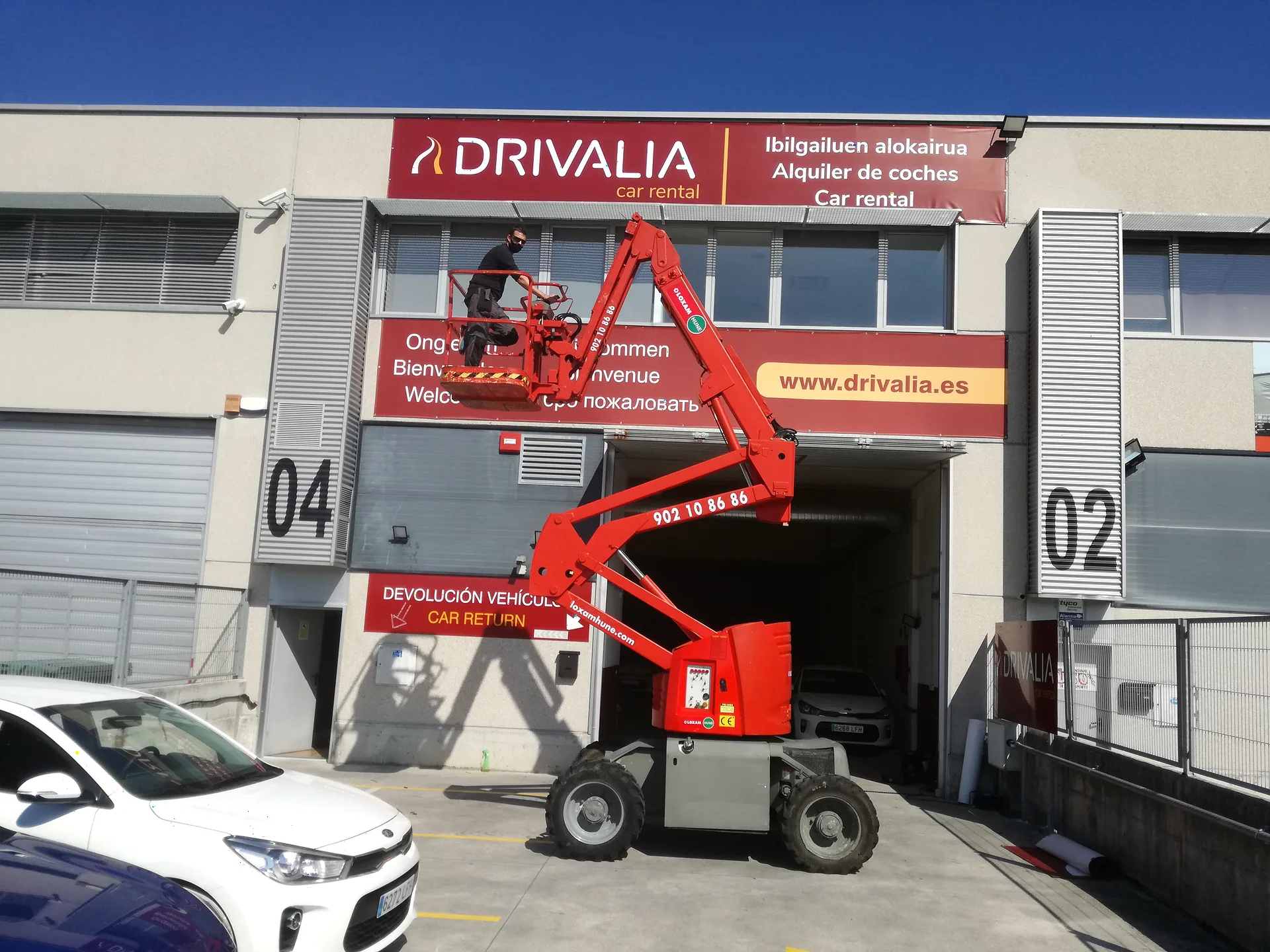 Instalación: Rótulo corporativo de fachada — Drivalia Instalación de rótulo corporativo de fachada de Drivalia en una nave o fachada industrial con brazo articulado.