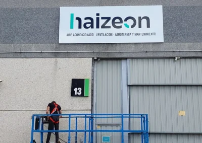Rótulo corporativo de fachada de Haizeon terminado en una nave o fachada industrial.
