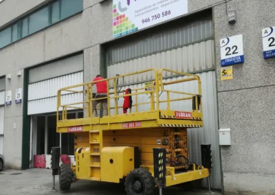 Instalación de rótulo de nave de Innova Sport en una nave o fachada industrial con plataforma de tijera.