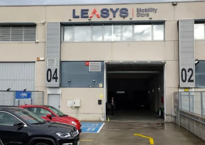 Rótulo corporativo de fachada de LEASYS Mobility Store terminado en una nave o fachada industrial.