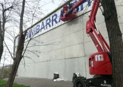 Instalación de letras corpóreas de gran tamaño en una nave o fachada industrial con brazo articulado.