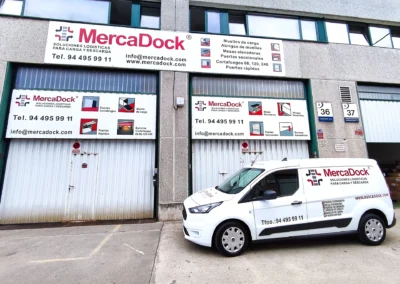 Conjunto de rótulos de nave de MercaDock terminado en una nave o fachada industrial.