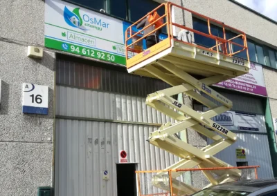Instalación de rótulo de nave de OsMar Energy en una nave o fachada industrial con plataforma de tijera.