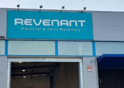 Rótulo corporativo de gran formato de Revenant terminado en una nave o fachada industrial.