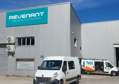 Rótulo corporativo de gran formato de Revenant terminado en una nave o fachada industrial.