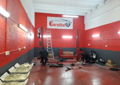 Instalación de rótulo interior de taller en la fachada de un taller con escalera.