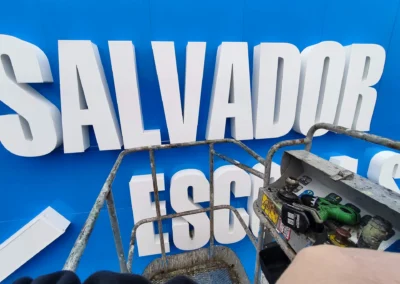 Detalle de letras corpóreas de gran tamaño de Salvador Escoda en una nave o fachada industrial.