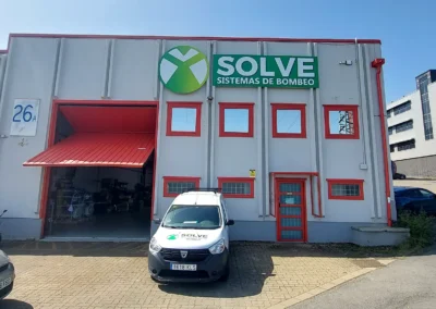 Rótulo corporativo de nave de Solve Sistemas de Bombeo terminado en una nave o fachada industrial.