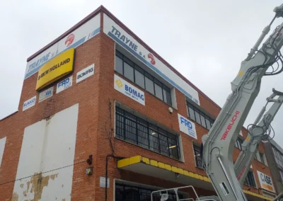 Conjunto de rótulos y placas de Trayne terminado en una nave o fachada industrial.