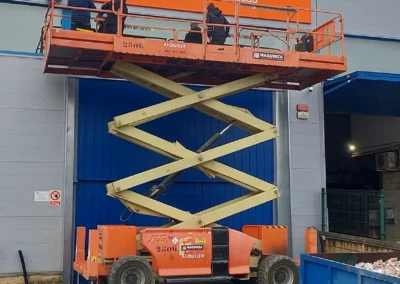 Instalación de rótulo corporativo de gran formato de Vibacar en una nave o fachada industrial con plataforma de tijera.