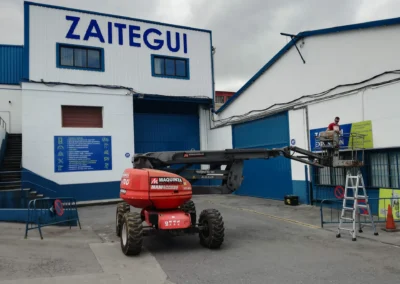 Instalación de rótulo de nave de Zaitegui en una nave o fachada industrial con brazo articulado.