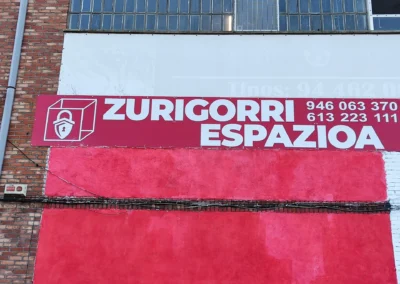 Detalle de rótulo de gran formato de Zurigorrri Espazioa en una nave o fachada industrial.
